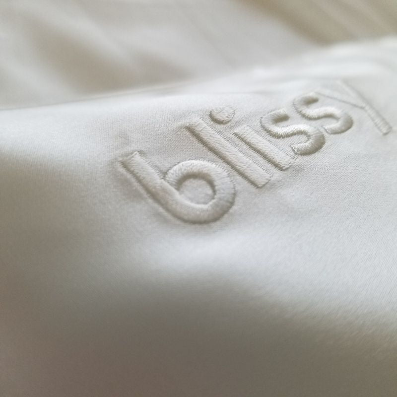 Close-up of 100 pure mulberry silk pillowcase fabric with embroidered logo, incredibly smooth texture